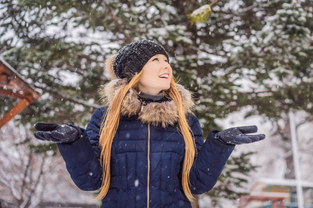 年轻女子在雪林里享受冬天的雪天