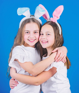 春节假期。快乐的童年。友谊的概念。复活节气氛。复活节快乐。节日兔子女孩长着兔子耳朵拥抱。儿童复活节兔子服装。活泼的女孩姐妹庆祝复