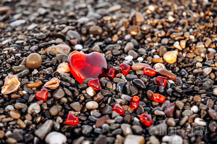 鹅卵石滩上的红心石头和心脏的背景