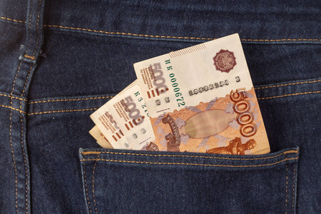 一条蓝色牛仔裤的后口袋里放着一堆5000卢布的。