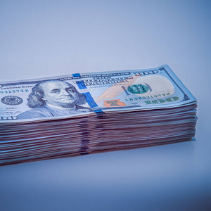 一大叠百元大钞.蓝色设计.图像四周暗角.照片