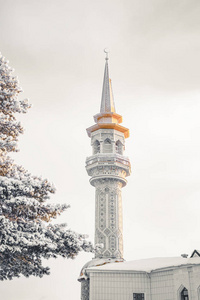 冬天西伯利亚松树后面的清真寺尖塔。