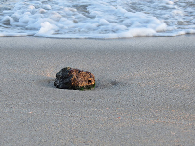 沙滩上的海浪和沙滩上的海滩石。背景。柔和聚焦。