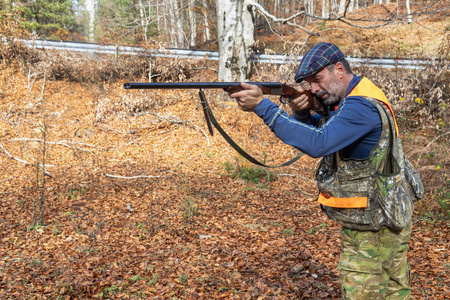 带着的猎人在森林里追逐照片