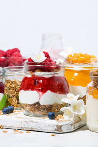 desserts with muesli, berries and fruit in jars, vertical 