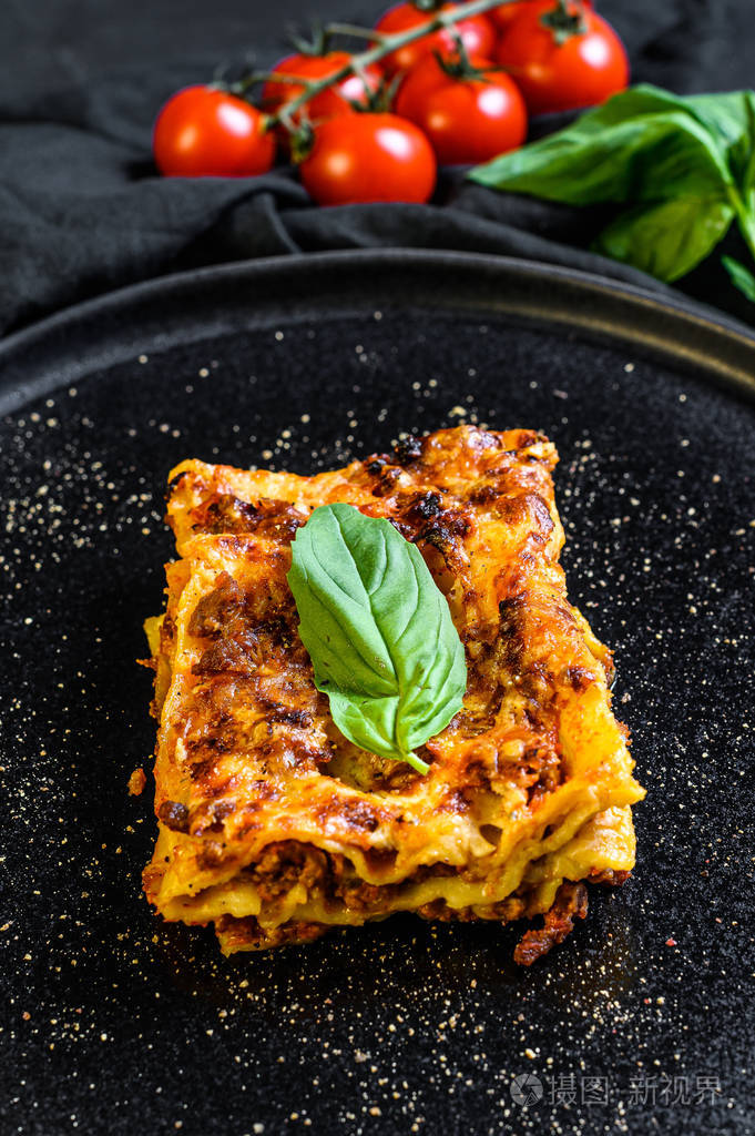一块美味的热烤宽面条意大利传统食物黑色背景俯视图