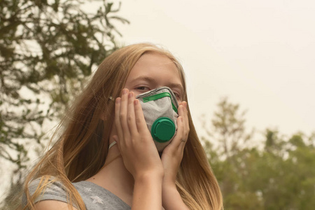 澳大利亚丛林大火金发女孩戴着P2防护呼吸面罩，以减少从丛林烟雾中呼吸PM2.5颗粒的量。