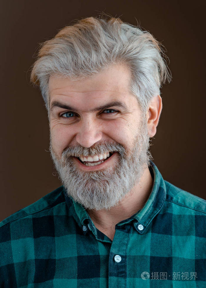 在黑暗背景下的年轻胡子男人的特写脸-专业工作室灯光.