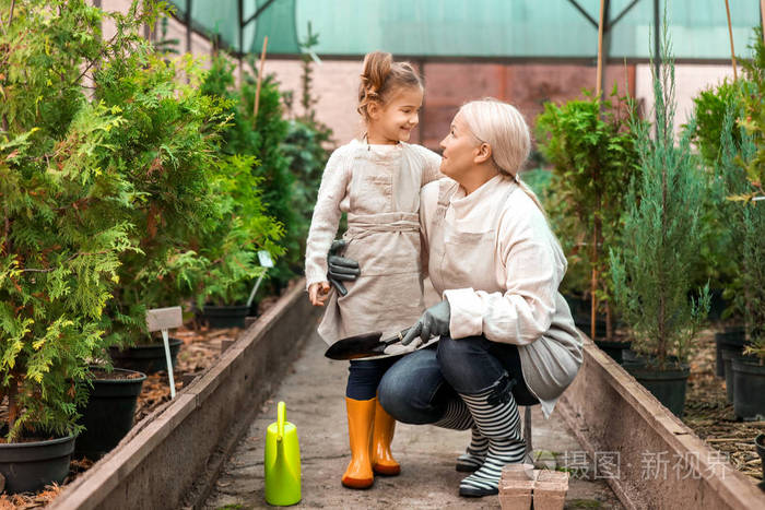 可爱的小女孩和奶奶在温室里