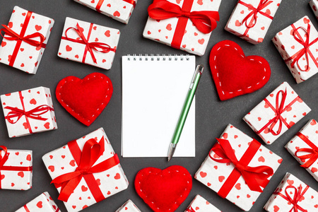 节日组成的笔记本，礼品盒和红色纺织心形在彩色背景下为您设计的空白空间。情人节概念俯视图
