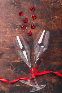 情人节贺卡，香槟酒杯，装饰心和红色丝带在木质背景上复制空间俯视图