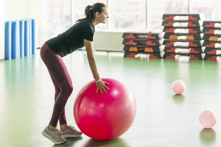 一个女人在健身房练习普拉提球