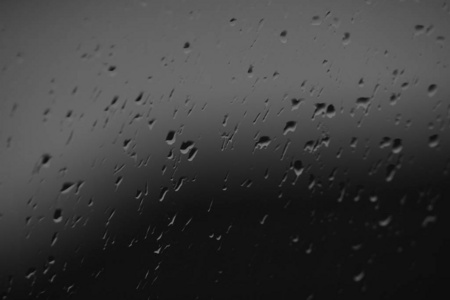 雨滴中的窗户，玻璃上水滴的特写镜头，bw照片。