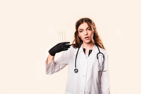 快乐美丽的女医生穿着医用外套，双臂交叉，站在白色的衣服上
