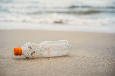 Plastic bottle on sand beach background. 