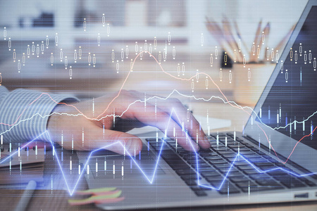两次曝光股票市场图形，背景是人在笔记本电脑上工作。财务分析的概念。