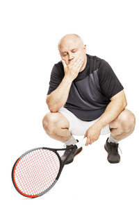 A bald man in an adult in a sports uniform with a tennis racket 