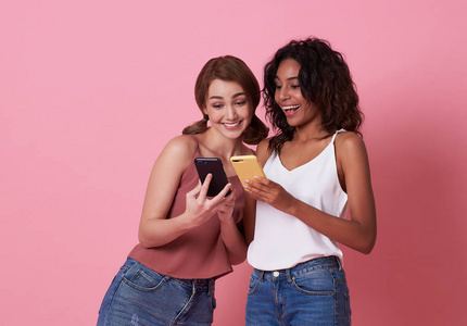 两个快乐的女性朋友在一个智能手机里玩和分享社交媒体。
