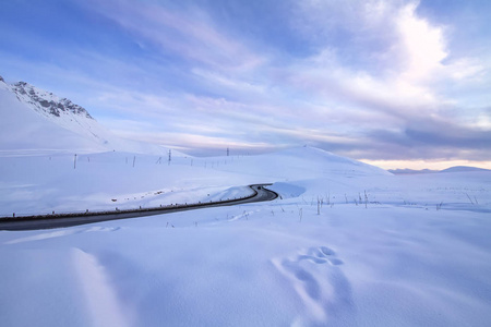 日落时格鲁吉亚军用公路上白雪皑皑的山脉之间的交叉口