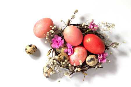 白色背景的巢中装饰性的粉红色复活节彩蛋。