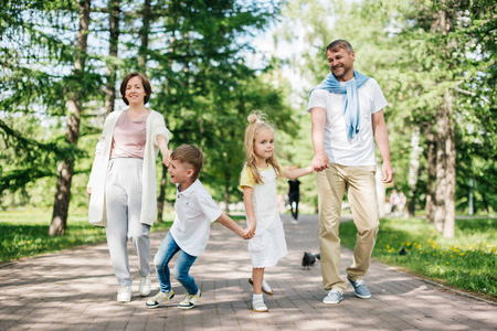 一个幸福的大家庭带着两个孩子在公园里散步。