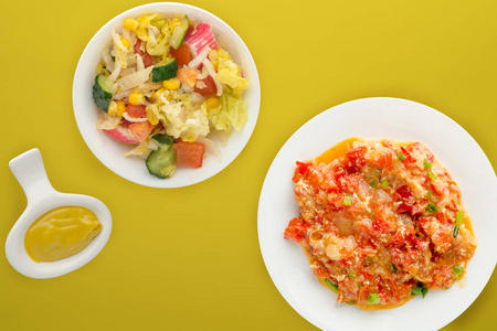  Stewed tomatoes with onions in a white  plate on a colored back