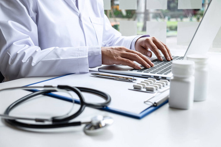 Doctor working with laptop in hospital and medical stethoscope, 