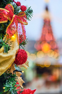 背景模糊的树枝上的圣诞装饰品，形状像一棵带灯的圣诞树。