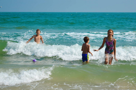 有趣的孩子在海里玩耍。男孩们在海水中溅水。热带家庭度假。孩子们在海里玩耍。