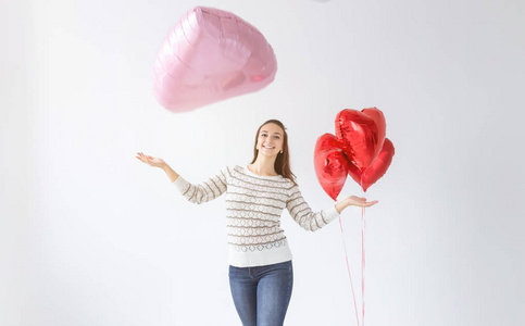 美丽的年轻女子与心形气球在白色背景上复制空间。情人节的女人。爱的象征