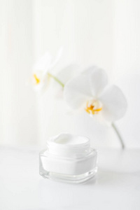 Face cream moisturizer jar and orchid flower, moisturizing skin 