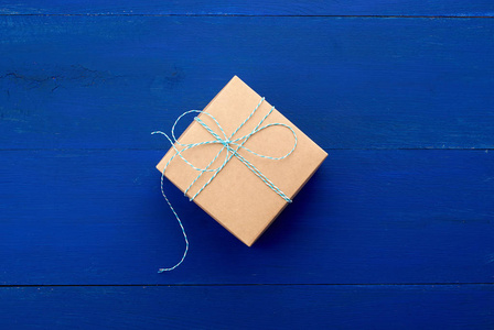 蓝色木质背景的棕色纸板礼品盒