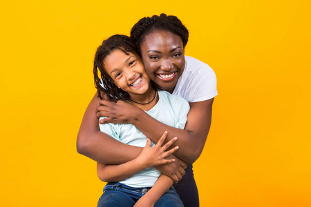 黑人母亲和她微笑的女孩拥抱图片