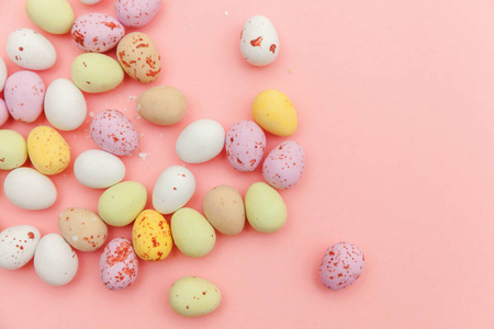 复活节快乐概念。复活节糖果巧克力蛋和果冻糖孤立在时尚的粉彩背景上。简约简约平铺俯视图复印空间