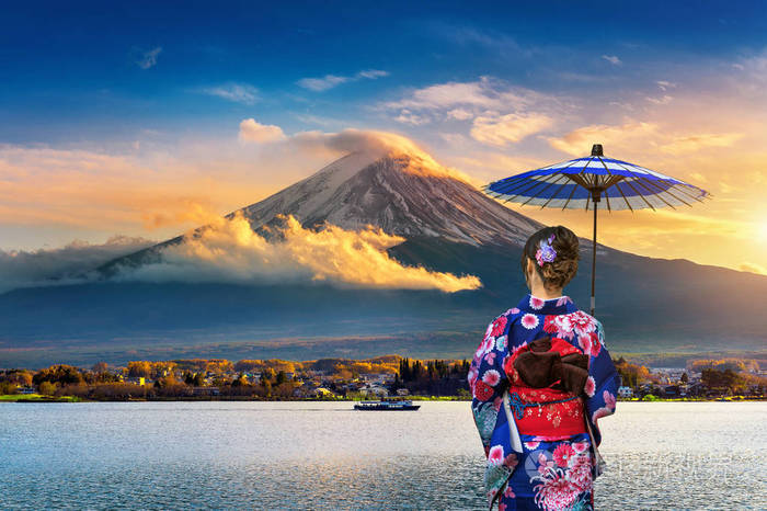 穿着日本传统和服的亚洲妇女在富士山日本川崎湖的日落