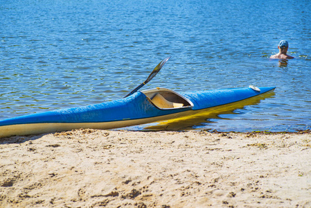 皮艇运动概念。皮划艇在海滩上。蓝色和黄色的皮艇。河岸上的船。夏日阳光明媚。皮划艇运动。