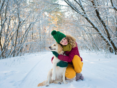 雪地里玩金毛猎犬的女青年