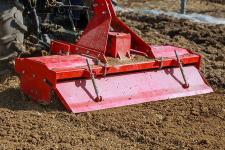 田间有犁的小型拖拉机.培养.照片