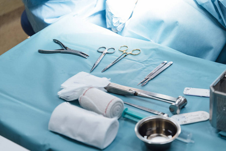 手术室里一组医疗工具放在手术室里不认识的外科医生附近的灯光下