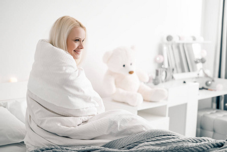 Attractive woman sitting on bed in the morning. 