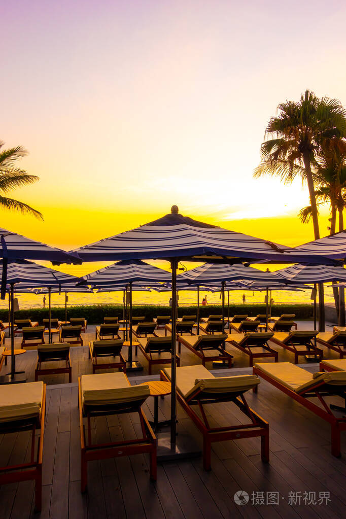 umbrella and chair around outdoor swimming pool in hotel resort 