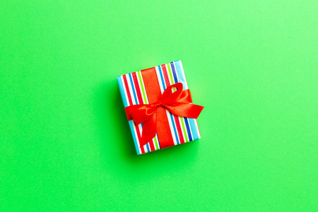 包装圣诞或其他节日手工礼品纸红色丝带绿色背景。礼品盒，彩桌上的礼品装饰，带复印空间的顶视图