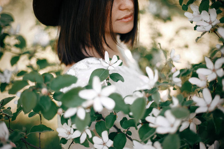 性感的肖像，美丽的时髦女人戴着帽子闻着whi