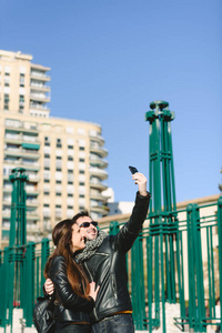 Couple of tourists embraced making themselves a selfie photo in 