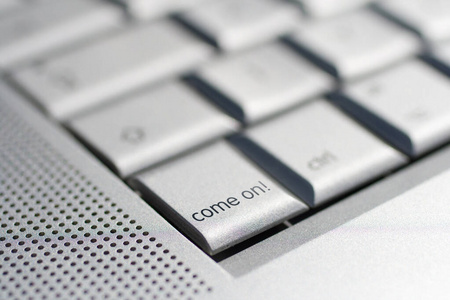 Close up shot of a laptop keyboard with a come on key in focus