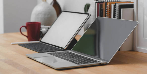 Close up view of workspace with mockup laptop, tablet and offic