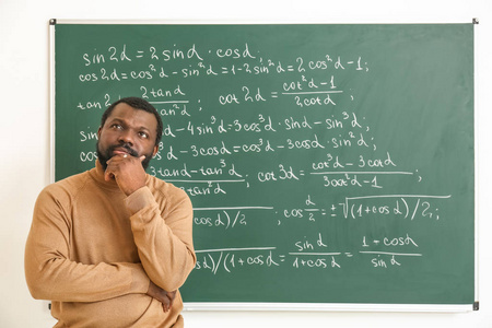 体贴的非裔美国数学老师在教室的黑板旁