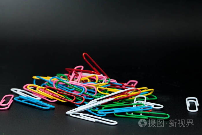黑色背景上的一堆不同颜色的回形针