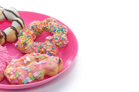 粉红色盘子上的彩色甜甜圈特写镜头