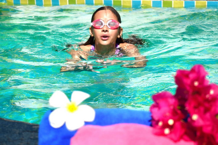 游泳池里的乐趣。热带旅行愉快。夏天女孩在室外游泳池游泳。